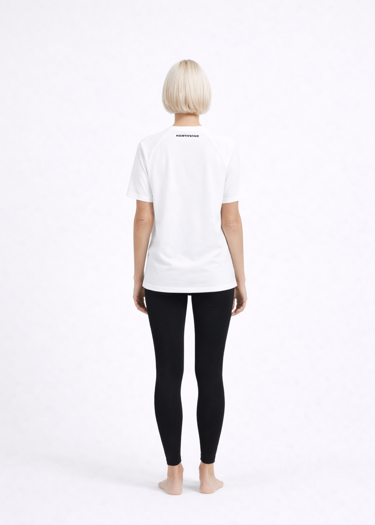Woman wearing a white Northwind activewear t-shirt with Northwind on the back and black legging for yoga