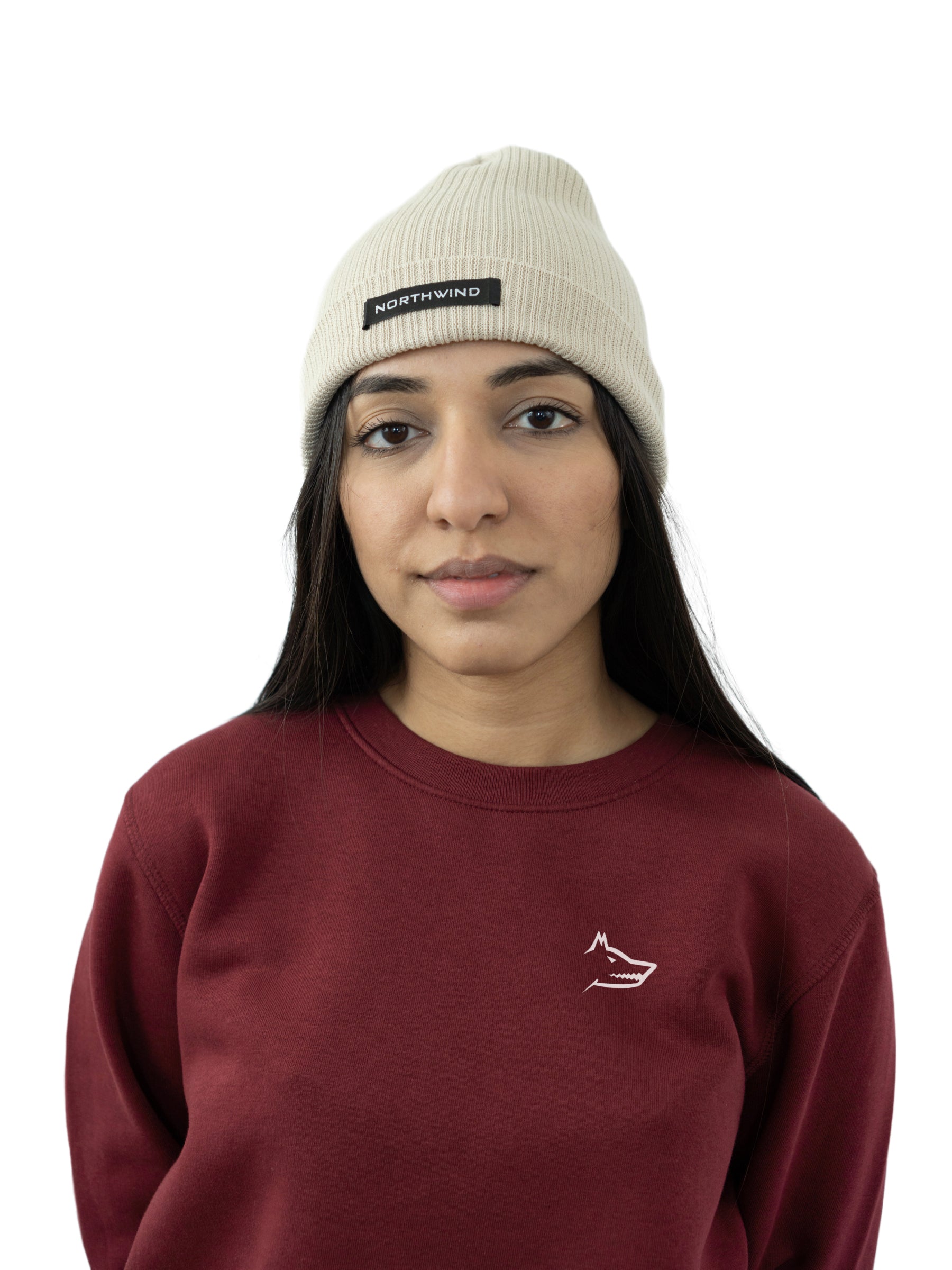 Woman wearing a beige organic cotton beanie with a Northwind brand logo, and a Northwind sweatshirt on a white background