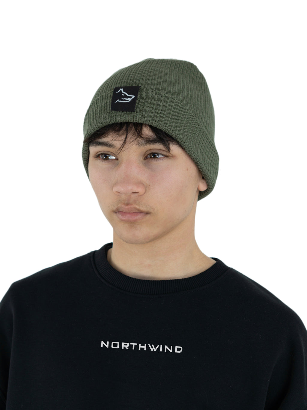 Man wearing a olive green organic cotton beanie with a Northwind wolf logo, and a black organic oversize Northwind sweatshirt with embroidered logo on the chest